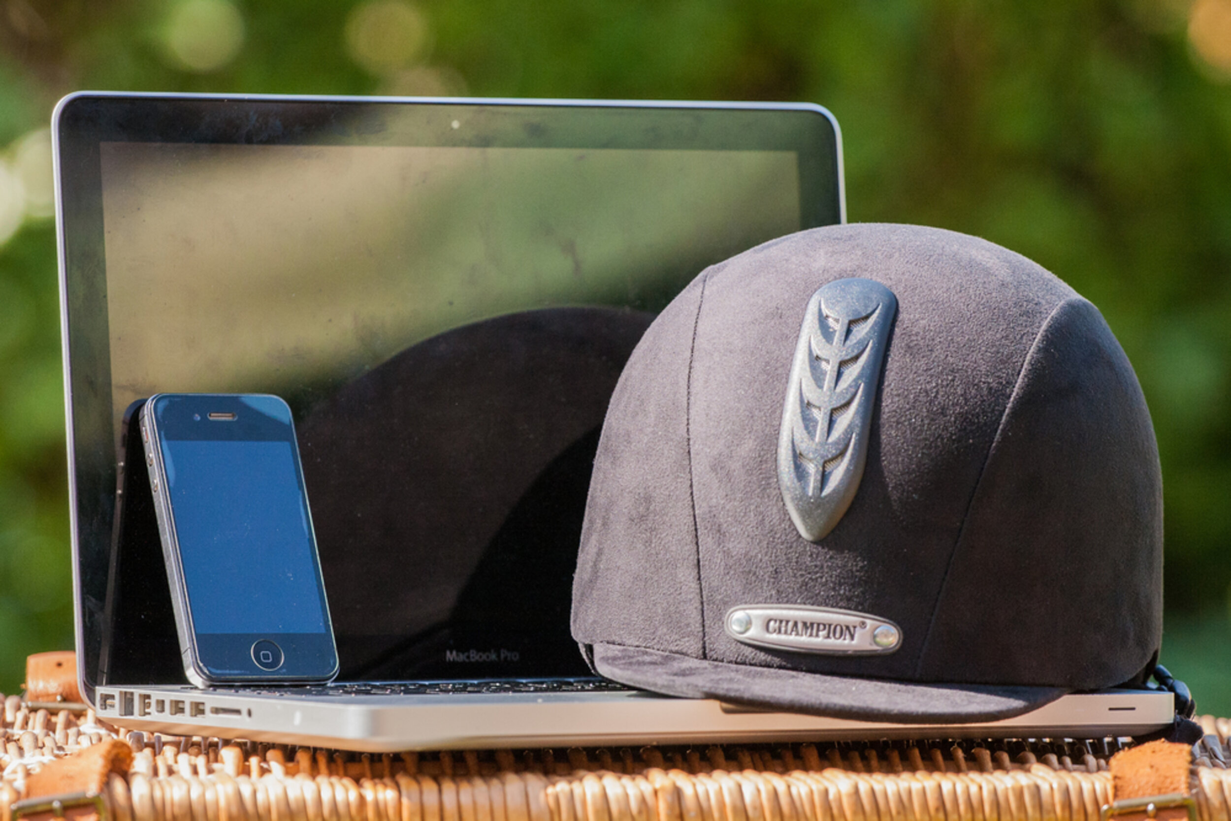A laptop, a phone and a riding hat